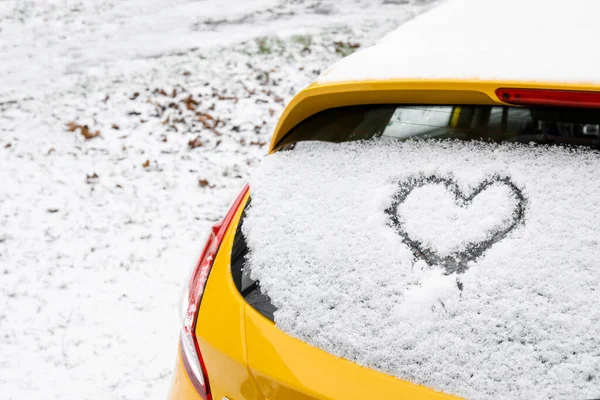 Kalp karla kaplı arabanın arka camına çizilmiş.