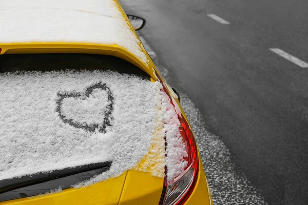 Kalp karla kaplı arabanın arka camına çizilmiş.