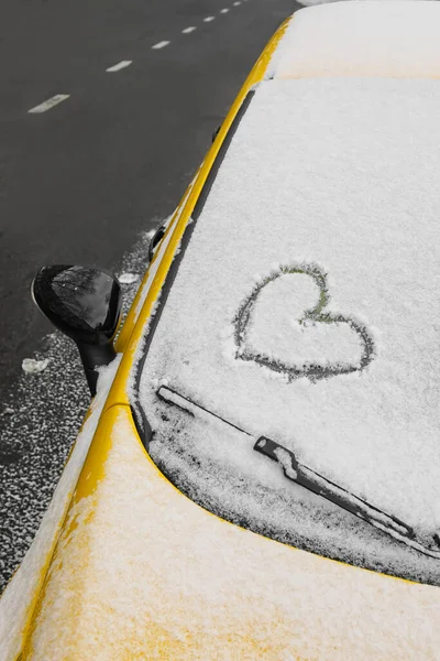 Kalp karla kaplı arabanın ön camına çizilmiş.