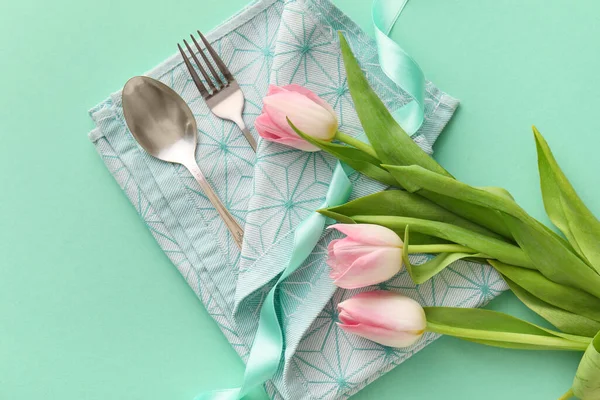 Turkuaz arka planda lale çiçekli şık çatal bıçak takımı