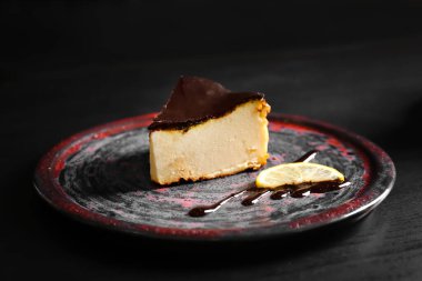 Koyu arkaplanda lezzetli Bask peynirli kek dilimi.