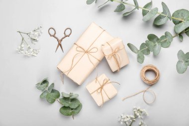 Beyaz arkaplanda hediye kutuları, makas ve halatla kompozisyon