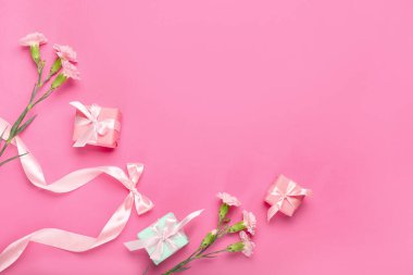 Renkli arkaplanda hediye kutuları ve çiçeklerle kompozisyon