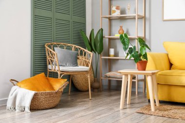 Koltuğu, sehpası ve çiçekleri olan modern oturma odasının içinde.