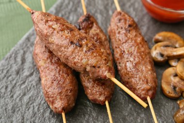 Lezzetli lula kebabı olan şiş panoları masada, yakın plan.
