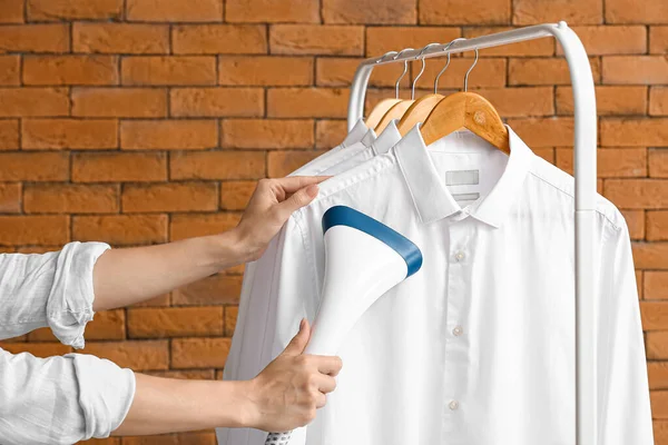 Vrouw Strijken Shirts Met Stoom Buurt Van Baksteen Muur — Stockfoto