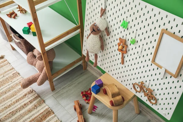 Plank Unit Met Speelgoed Pegboard Kruk Bij Groene Muur — Stockfoto