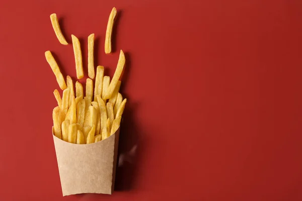 Caja Papel Con Sabrosas Papas Fritas Sobre Fondo Rojo — Foto de Stock