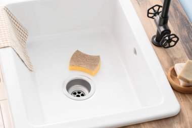 Mutfakta temizlik süngeri olan seramik lavabo, yakın çekim.