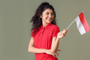 Endonezya bayrağıyla gülümseyen Asyalı kadın renk arkaplanına bakıyor