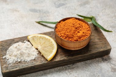 Hafif zemin üzerinde zerdeçal tozu ve limon olan tahta, yakın plan