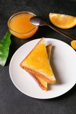 Koyu arkaplanda lezzetli turuncu reçelli tost.