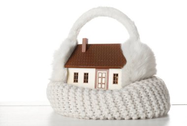 Beyaz arka planda kulaklık ve eşarplı ev modeli. Isıtma kavramı