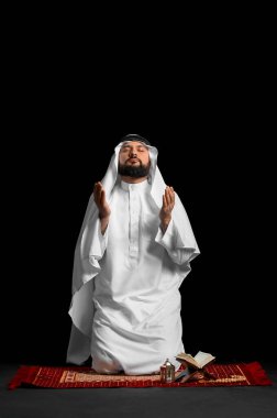 Müslüman adam siyah arka planda dua ediyor