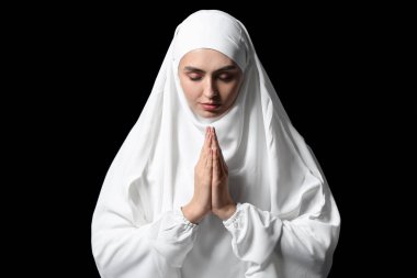 Karanlık arka planda dua eden Müslüman kadın