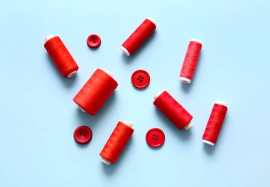 Mavi arkaplanda iplik makaraları ve düğmeler