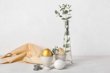 Güzel Paskalya yumurtaları ve okaliptüs dalları olan tutucular