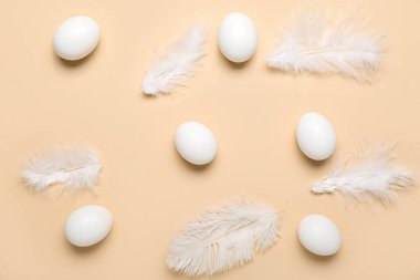 Renkli arka planda tavuk yumurtaları ve tüyler