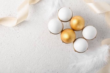 Güzel Paskalya yumurtaları ve hafif arka planda tüyleri olan tutucu.