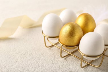 Arka planda güzel Paskalya yumurtaları olan altın tutucu, yakın plan.