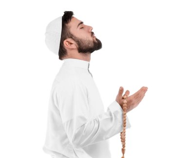 Beyaz arka planda dua eden genç Müslüman.