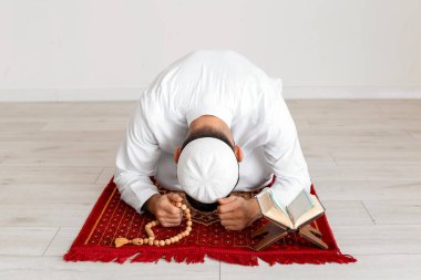 Evinde dua eden genç bir Müslüman.