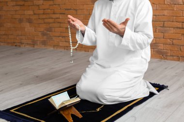 Evinde dua eden genç bir Müslüman.