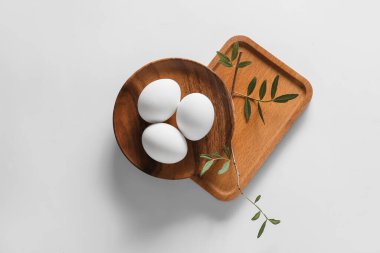 Paskalya yumurtaları ve açık arkaplanda yeşil bir dal.