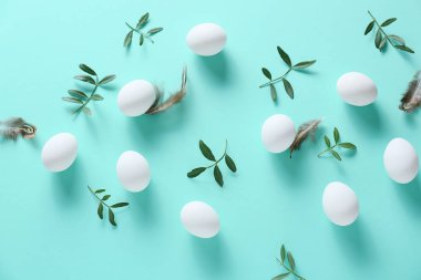 Paskalya yumurtaları ve turkuaz arka planda yeşil dallar