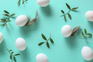 Paskalya yumurtaları ve turkuaz arka planda yeşil dallar