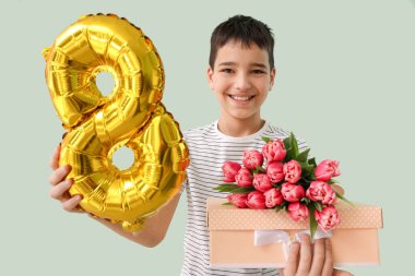 Balonlu, laleli ve yeşil arka planda hediye kutusu olan küçük bir çocuk. Uluslararası Kadınlar Günü