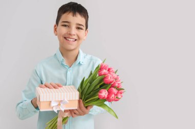 Laleli ve arka planda hediye kutusu olan küçük bir çocuk. Uluslararası Kadınlar Günü