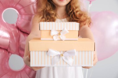 Küçük kızıl saçlı kız hediye kutuları ve balonlarla arka planda, yakın plan. Uluslararası Kadınlar Günü