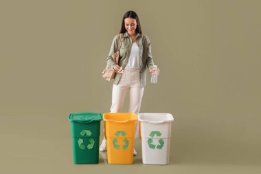 Plastik şişe ve kâğıt renklerini sınıflandıran genç bir kadın.
