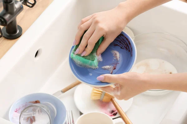 女人用海绵在洗碗槽上洗碗 — 图库照片