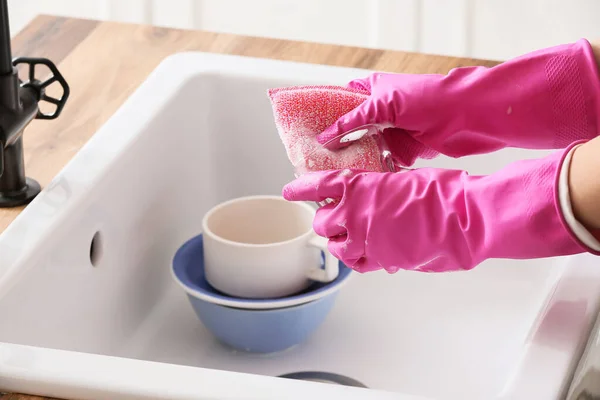 戴着橡胶手套的家庭主妇用海绵在水槽上洗玻璃杯 — 图库照片