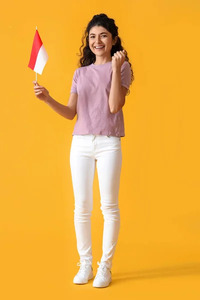 黄色の背景にインドネシアの小さな旗を持つ幸せなアジアの女性 — ストック写真