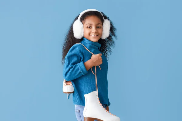 Kleines Afroamerikanisches Mädchen Mit Ohrenschützern Und Schlittschuhen Auf Blauem Hintergrund — Stockfoto