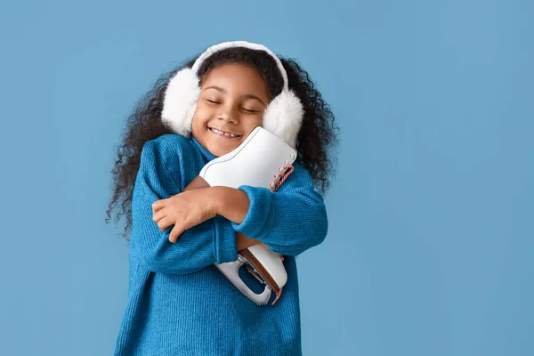 Kleines Afroamerikanisches Mädchen Mit Ohrenschützern Und Schlittschuhen Auf Blauem Hintergrund — Stockfoto