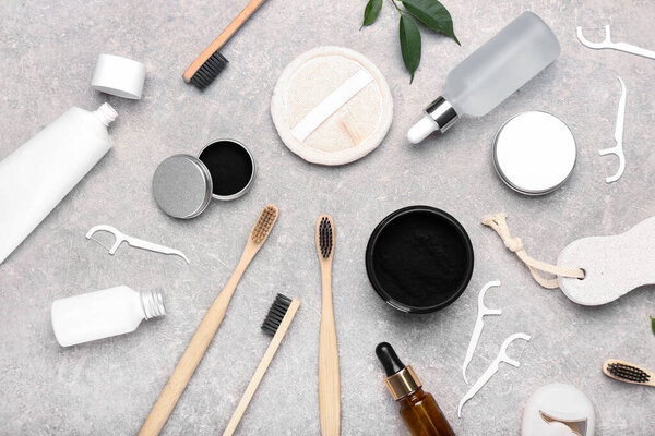 Состав с активированным угольным зубным порошком, зубными щетками и зубными зубочистками на сером фоне