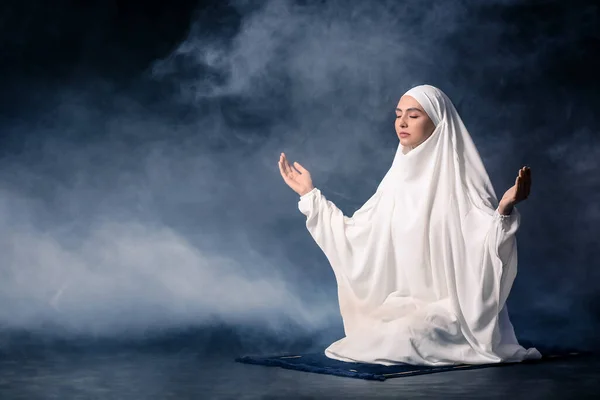暗い背景で祈るイスラム教徒の女性 — ストック写真