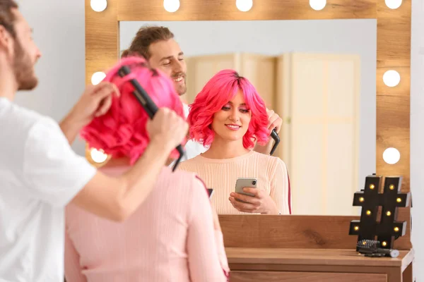 美容室で若い女性の髪をやって男性スタイリスト — ストック写真