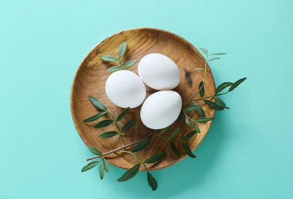 Paskalya Yumurtası Turkuaz Arka Planda Yeşil Dallı Bir Tabak — Stok fotoğraf