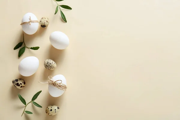 Paskalya Yumurtaları Bej Arka Planda Yeşil Dallarla Kompozisyon — Stok fotoğraf