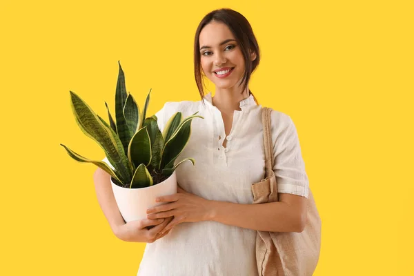 Junge Frau Mit Zimmerpflanze Und Öko Tasche Auf Gelbem Hintergrund — Stockfoto