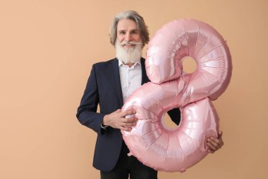 Renkli arka planda şekil 8 şeklinde balon tutan son sınıf öğrencisi. Uluslararası Kadınlar Günü kutlamaları