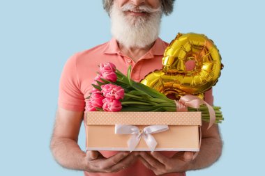 Elinde hediye kutusu, laleler ve balon olan son sınıf öğrencisi sekiz renk arka planda, yakın plan. Uluslararası Kadınlar Günü kutlamaları