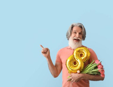 Laleli ve balonlu yaşlı adam şekil 8 şeklinde renkli arka planda bir şeyi işaret ediyor. Uluslararası Kadınlar Günü kutlamaları