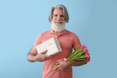 Elinde hediye kutusu ve renkli laleler tutan son sınıf öğrencisi. Uluslararası Kadınlar Günü kutlamaları