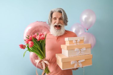 Renkli arka planda laleler ve hediye kutuları tutan duygusal son sınıf öğrencisi. Uluslararası Kadınlar Günü kutlamaları